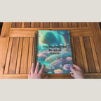 Overhead video of hands opening and flipping through the spiral-bound NeuroMythical planner.