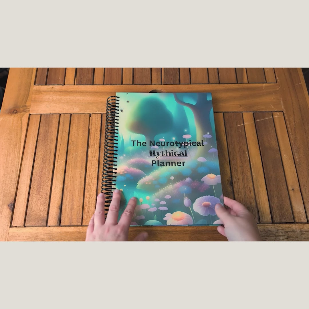 Overhead video of hands opening and flipping through the spiral-bound NeuroMythical planner.